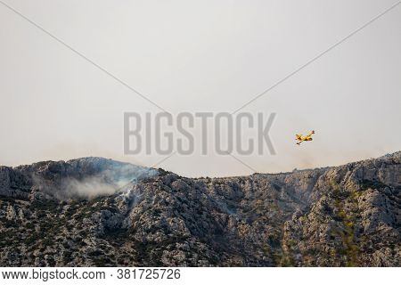 A Fire Fighting Water Bomber Dropping Water On A Forest Fire On Top Of The Kozjak Mountain In Croati