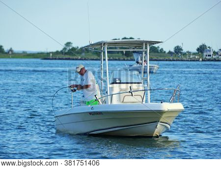 Bethany Beach, Delaware, U.s.a - August 1, 2020 - A Man Reeling A Big Fish On The Boat Near Indian R