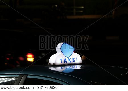 Taxi Light Sign Or Cab Sign In Blue And White Color On The Car Roof At The Street In The Dark Night,