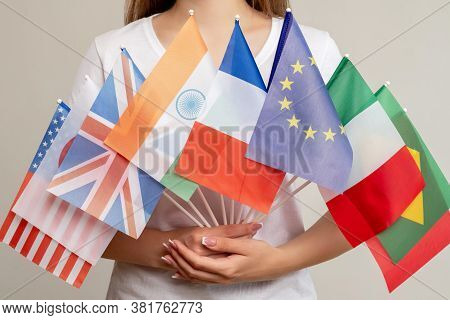World Peace. Global Unity. Woman Holding International Flags Isolated On Light Background. Political