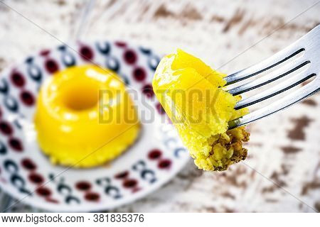 Piece Of Quindim, Small Pudding Cut From Brazilian Egg, With Sugar And Grated Coconut. Macro Or Clos