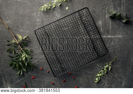 Top View On The Decorated Grey Concrete Background With Black Grid Cake Tray