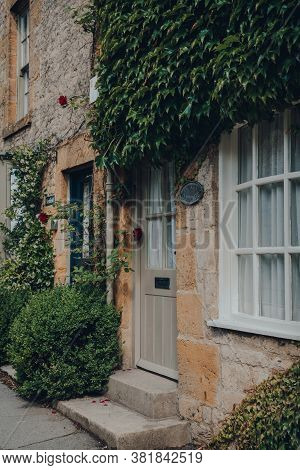 Stow-on-the-wold, Uk - July 10, 2020: Front Of A House, Partially Covered With Wall Climbing Plants 