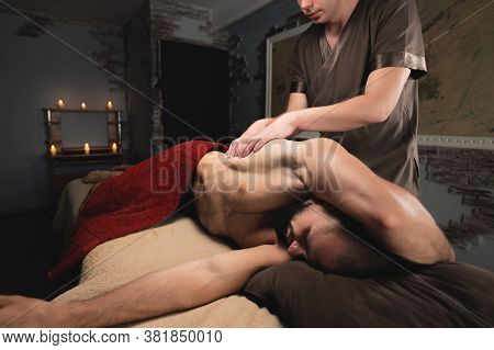 Professional Sports Massage Male Masseur Makes An Athlete A Man. Latissimus Dorsi Lats Massage