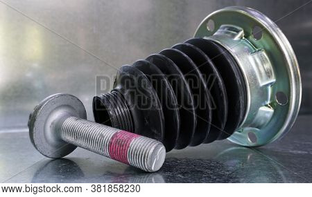 The New Protective Cover Of The Drive Shaft Of A Modern Car And The Hub Bolt On A Steel Background. 