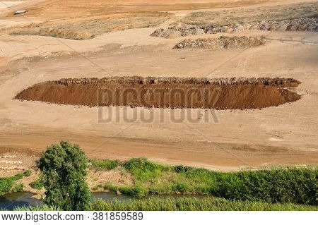 A Large Pit Dug In The Field. Large Pit. Deep Sand Pit Dug For Trash In The Field. House Constructio
