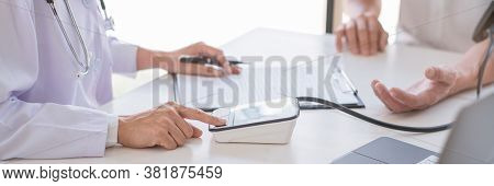 Doctor Using Sphygmomanometer Or Tonometer Measuring Blood Pressure To A Patient Examined The Heartb