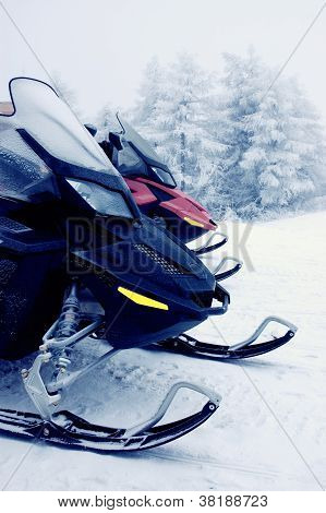 zwei Motorschlitten in den Bergen