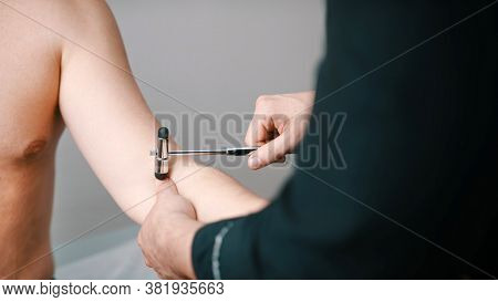 The Neurologist Checks The Reflex Of The Patients Hand. High Quality Photo