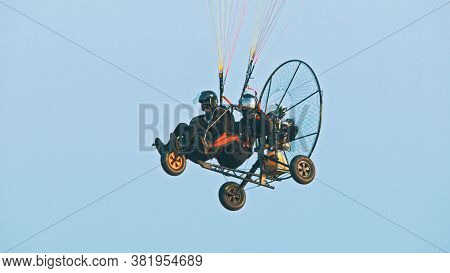 Tandem Paramotor Gliding - Two Men Flying And Gliding In The Air. High Quality Photo