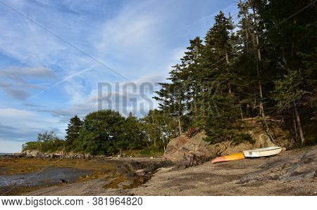 Kayak And Row Boat Beached At Low Tide In Maine.