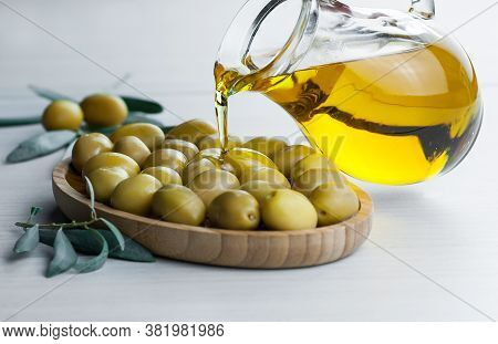 Glass Bottle Of Homemade Olive Oil And Olive Tree Branch, Raw Turkish Green Olive Seeds And Leaves O