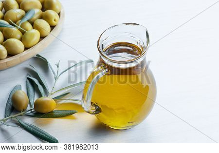 Glass Bottle Of Homemade Olive Oil And Olive Tree Branch, Raw Turkish Green Olive Seeds And Leaves O