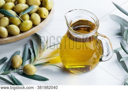 Glass Bottle Of Homemade Olive Oil And Olive Tree Branch, Raw Turkish Green Olive Seeds And Leaves O