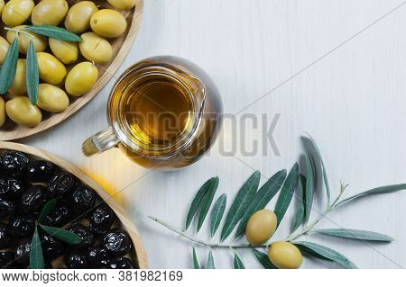Glass Bottle Of Homemade Olive Oil And Olive Tree Branch, Raw Turkish Green Olive Seeds And Leaves O