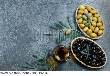 Glass Bottle Of Homemade Olive Oil And Olive Tree Branch, Raw Turkish Green And Black Olive Seeds An