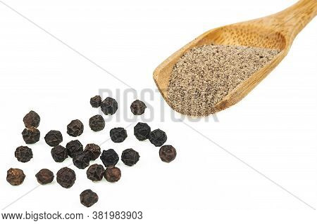 Close Up Heap Of Black Pepper In Wooden Spoon, Peppercorns And Milled Pepper Powder Isolated On Whit