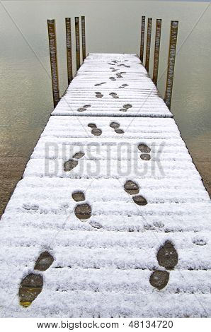 Footprints In Snow On A Dock
