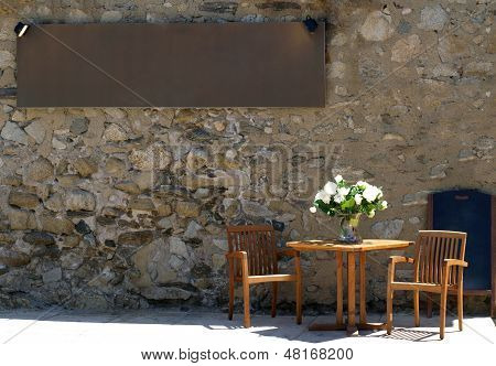 Restaurant With Table Outside In The Yard And Menu Board
