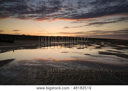 Vibrant Sunrise Landscape Reflected In Low Tide Water On Beach