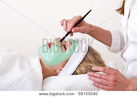Beautician Applying Facial Mask On The Cheekbones.