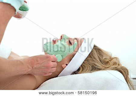 Beautician Applying Green Facial Mask On A Woman.