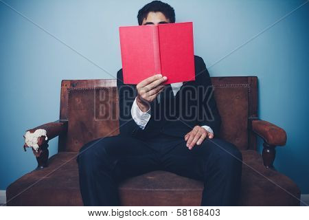 Businessman On Sofa Is Reading