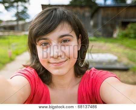 Teengirl taking a self-portrait out in the country house.