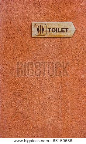 Wooden Toilet Sign On The Orange Wall