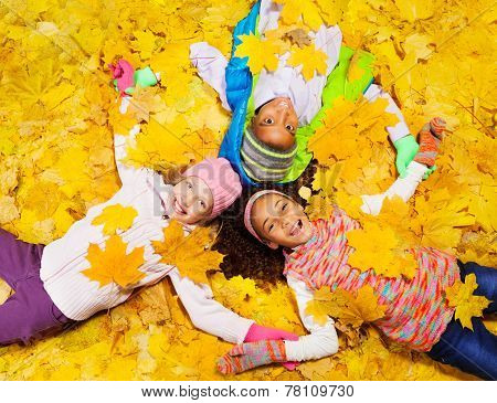 Kids play with autumn maple orange leaves