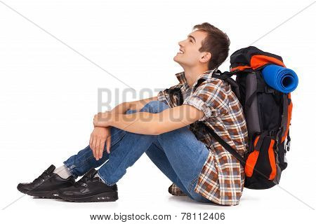 Smiling hiker sitting with knapsack