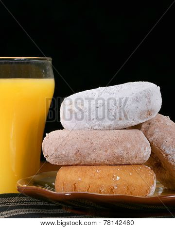 Assorted donuts on a plate with orange juice