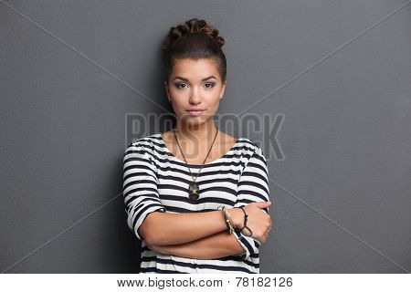 A young woman standing, isolated on graybackground.