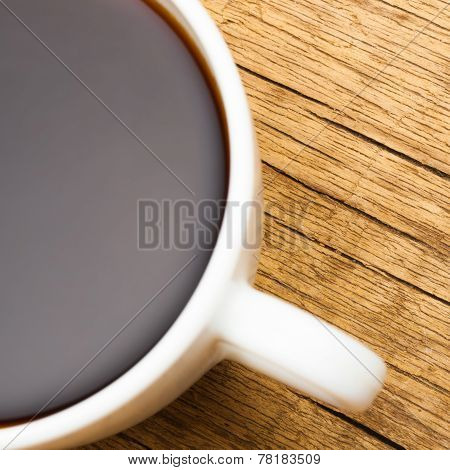 Close Up Of White Ceramic Coffee Cup On Wooden Table - View From Top