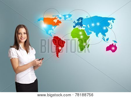 Beautiful young woman holding a phone and presenting colorful world map