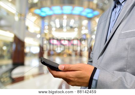 Handsome Young Man In Shopping Mall Using Mobile Phone