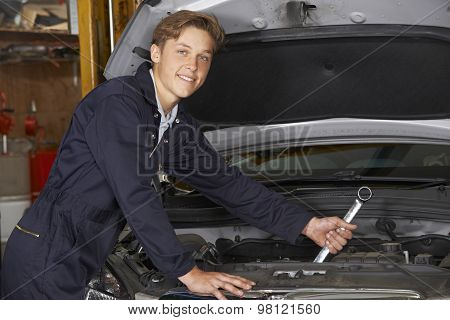 Apprentice Mechanic In Auto Shop Working On Car Engine