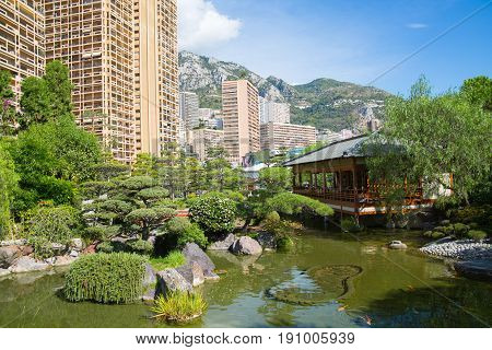 Monaco, Monte Carlo - September 17, 2016: Jardin Japonais, Japanese Garden view with residential buildings at the background.