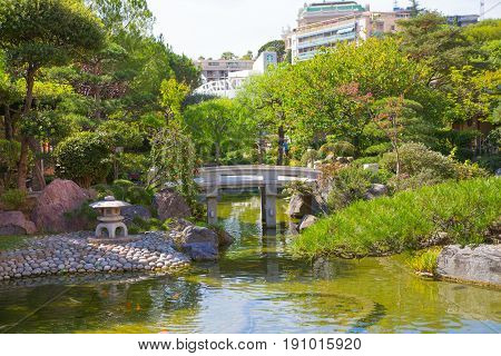 Monaco, Monte Carlo - September 17, 2016: Jardin Japonais, Japanese Garden view with residential buildings at the background.