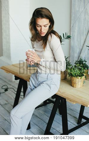 young woman relaxing at home in modern scandinavian interior