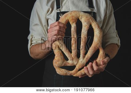 Baker's hands hold fougas bread
