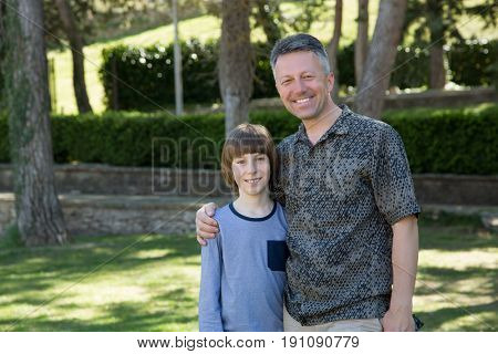 Portrait of father with his son having fun in summer park. Family leisure. Happy boy playing with dad summer nature outdoor