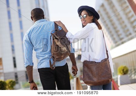 I got your back. Stylish happy modern people going for shopping together while heading to another mall and seeming excited