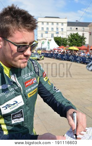 LE MANS FRANCE - JUNE 11 2017: Famous New Zealander racer Richie Stanaway Aston Martin Racing gives autograph during represantation of cars for competition 24 hours of Le mans
