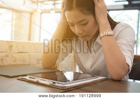 Young Woman Put Hand On Head Feeling Tired, Frustrated And Stressed From Hard Work While Sitting At
