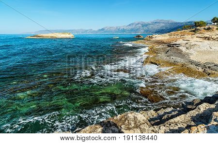 Waves break on rocky shore. Raging sea an elemental power in a storm. Clear day at sea coast. Tourist beach resort