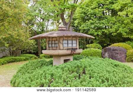 HIMEJI JAPAN - MAY 16 2017: Traditional stone lantern (toro) in Kokoen Garden near Himeji castle Japan. Garden was laid out in 1992 to commemorate 100 anniversary of Himeji city