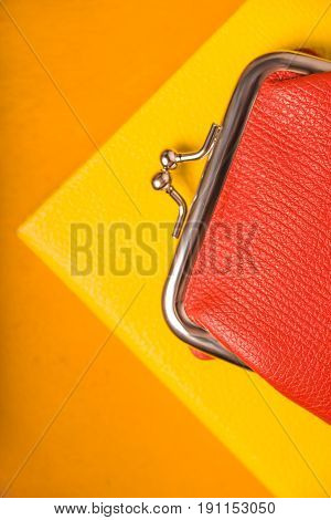 Orange purse on the bright yellow background top view vertical