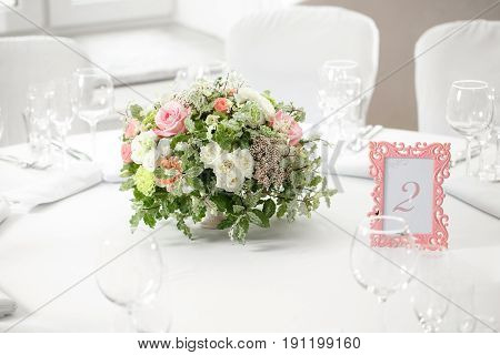 table setting, festive round tables ready for guests. Beautifully organized event. floral arrangement in the center. fresh flowers cut-off
