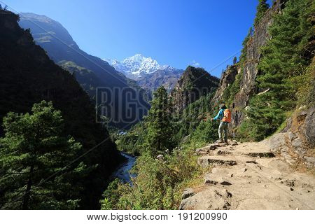 Young woman backpacker trekking at the himalaya mountains